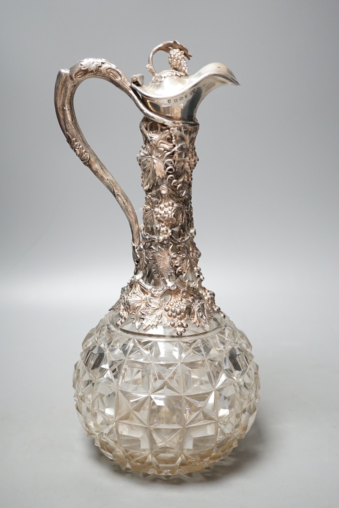 A Victorian silver mounted cut glass claret jug, with fruiting vine decoration, Cartwright & Woodward, Birmingham, 1860, 32cm.